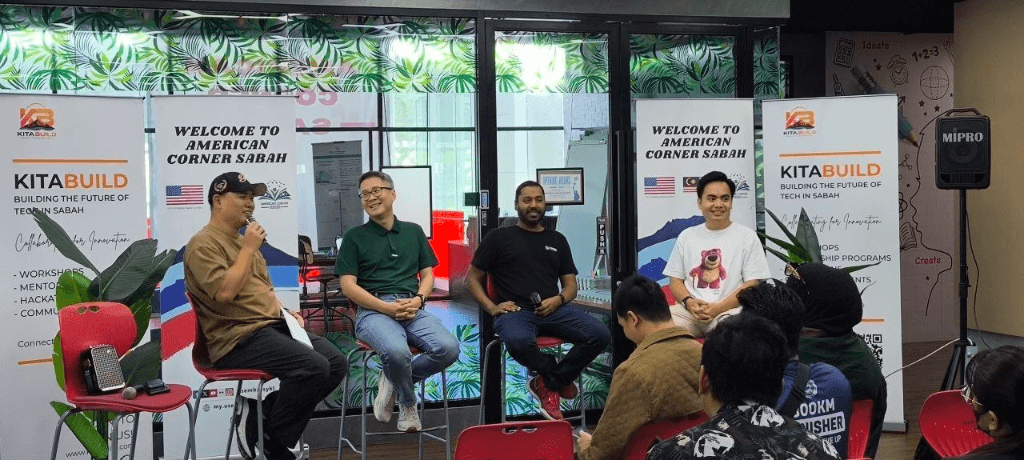 Mohd Shanizam speaking on the AI Innovation Panel at American Corner Sabah with KitaBuild banners